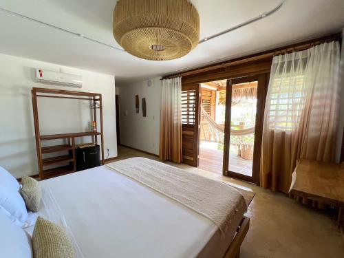 a bedroom with a bed and a large window at LaVentana Tatajuba in Tatajuba