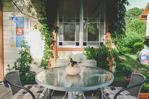 a glass table with a vase of flowers on it at Villa Irbe in Jūrmala