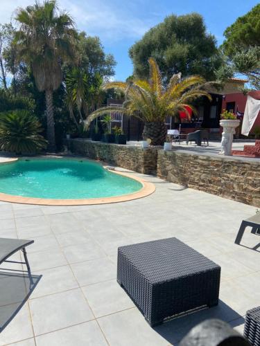 - une piscine avec une table et un banc sur une terrasse dans l'établissement Atelierchic, au Lavandou
