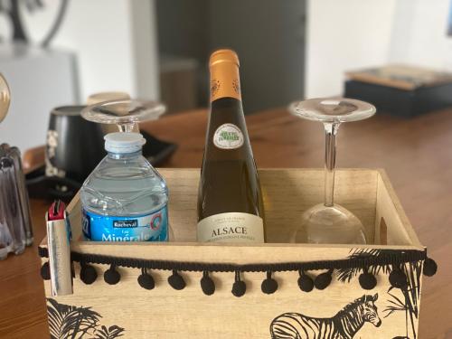 una caja de madera con 2 botellas de vino y una copa en Le clos des Pommiers, en Uffholtz
