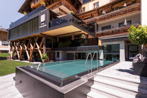 an external view of a house with a swimming pool at Hotel Kohlmais in Saalbach Hinterglemm