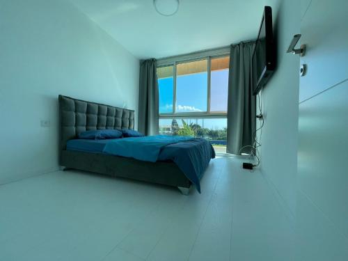 a bedroom with a bed and a large window at Ayelet Aviv in Caesarea