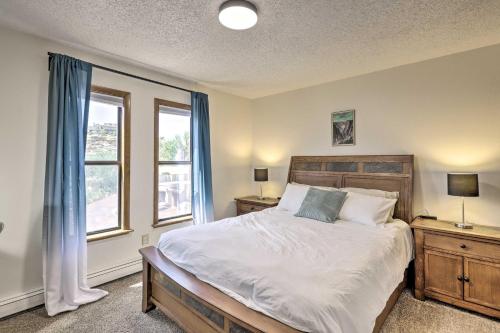 a bedroom with a large bed and two windows at Grand Junction Townhome about 3 Mi to Downtown! in Grand Junction