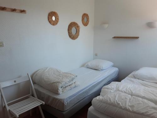 two beds in a room with two wreaths on the wall at Charmante maison de plain pied avec 700m2 de jardin cloturé in Saint-Clément-des-Baleines