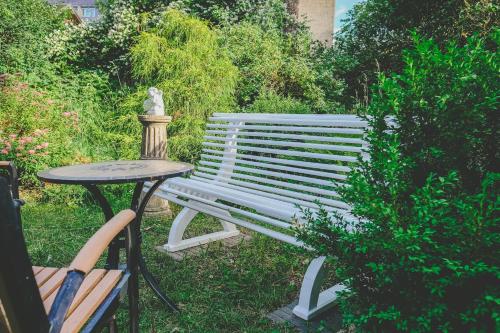 a bench and a table with a statue in a garden at Villa Irbe in Jūrmala