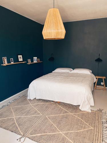 une chambre avec un lit et un mur bleu dans l'établissement Bô, Peace & Bordeaux, à Bordeaux