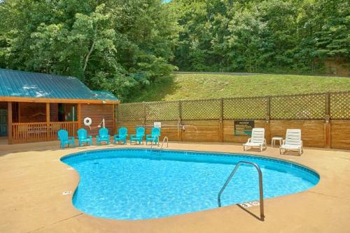 a swimming pool with chairs and a group at Forever Yours, 2 Hot tubs, FREE Attraction tickets, WIFI, Near The Parkway in Pigeon Forge!!! in Pigeon Forge