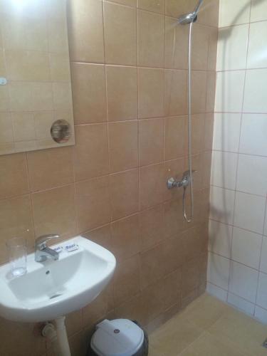 a bathroom with a shower with a sink and a toilet at Guest Rooms Venera in Primorsko