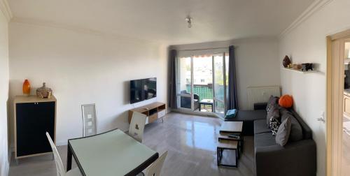 a living room with a couch and a table at Appartement avec belle vue et place de parking in Annemasse