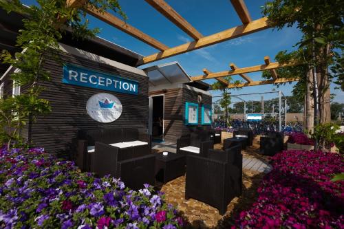 a rendering of a reception area with flowers at Marina Azzurra Resort in Lignano Sabbiadoro