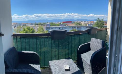 two chairs and a table on a balcony with a view at Appartement avec belle vue et place de parking in Annemasse