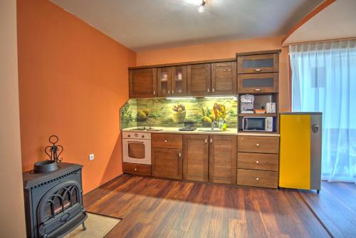 cocina con paredes de color naranja y fogones en Вила Capitalica Carpe, en Pamporovo