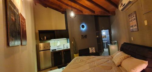 a bedroom with a bed and a kitchen in it at Ivy House Apart Hotel in Ciudad del Este