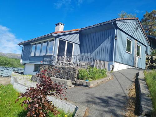 a blue house with a stone wall at Beautiful Villa with amazing view in Bergen. in Bergen