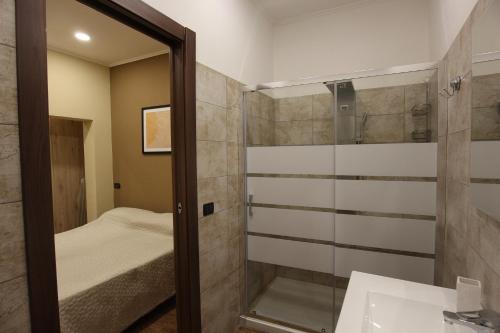 bagno con doccia, lavandino e specchio di La Casa D' Ogliastra tra mare e terra a Tortolì