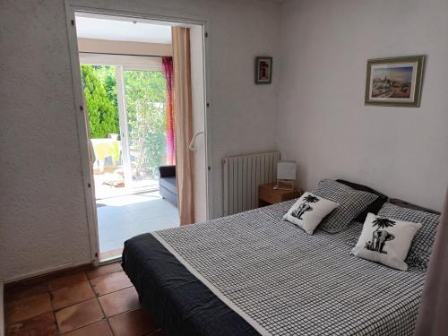 a bedroom with a bed and a sliding glass door at Chambre raisin 2p, pour 2 nuits max, a 6km du festival de piano de la roque d'anthéron à 100m de la piscine in Rognes