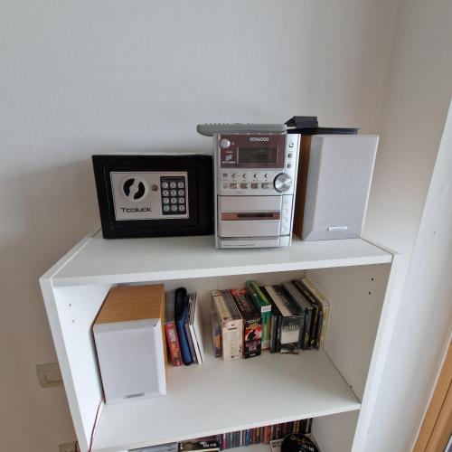 a microwave sitting on top of a shelf with books at Comfy Plaza in Aurolzmünster