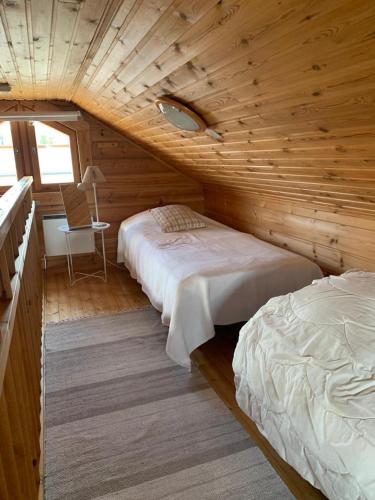 a bedroom with two beds in a log cabin at Yllästölli 2 A, Äkäslompolo in Kolari
