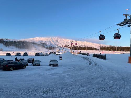 a group of cars parked on a snow covered road with a ski lift at Yllästölli 2 A, Äkäslompolo in Kolari