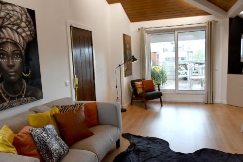 a living room with a couch and a large window at Orchid House - T1 Apartment in Braga