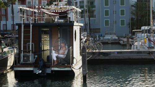 uma mulher sentada na parte de trás de um barco na água em La Maison Bateau Sotogrande em San Roque