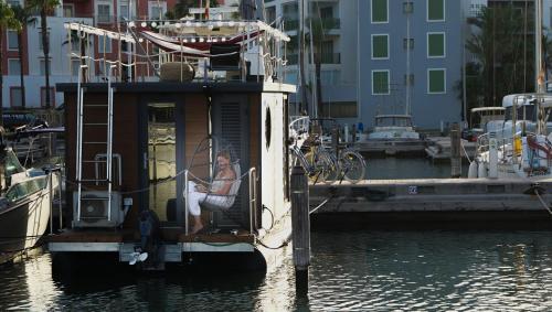 圣罗克La Maison Bateau Sotogrande的坐在水中船尾的女人