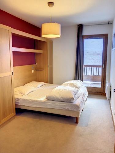 une chambre avec un grand lit et une fenêtre dans l'établissement Appartement station Sainte Foy Tarentaise, à Sainte-Foy-Tarentaise