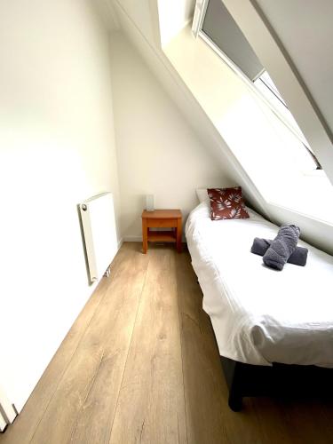 a attic bedroom with two beds and a window at The island life texel met jacuzzi in De Koog