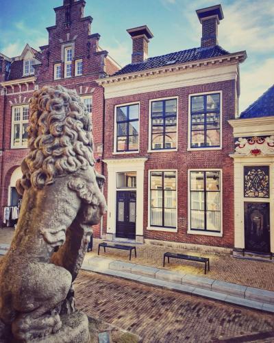 a statue in front of a large brick building at Elf bed and breakfast in Bolsward