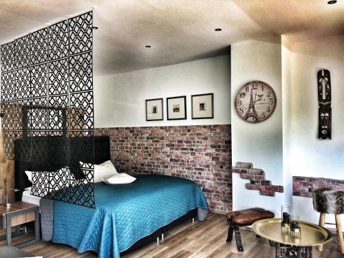 a bedroom with a blue bed and a brick wall at Kinzigloft nahe Frankfurt in Gelnhausen