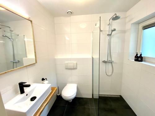 ein Bad mit einem WC, einem Waschbecken und einer Dusche in der Unterkunft The island life texel met jacuzzi in De Koog