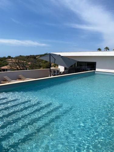 une piscine avec de l'eau bleue devant une maison dans l'établissement Residence LMG 