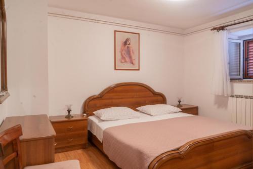 a bedroom with a bed and a table and a window at Rooms Ljubica in Cres