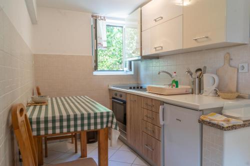 a small kitchen with a table and a sink at Rooms Ljubica in Cres