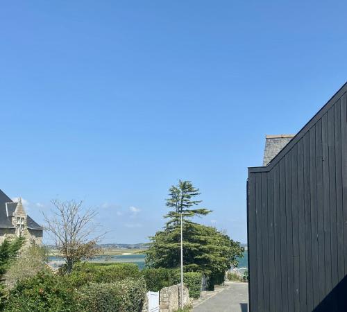 a black building with a view of a body of water at Le trait d'Union le Croisic in Le Croisic