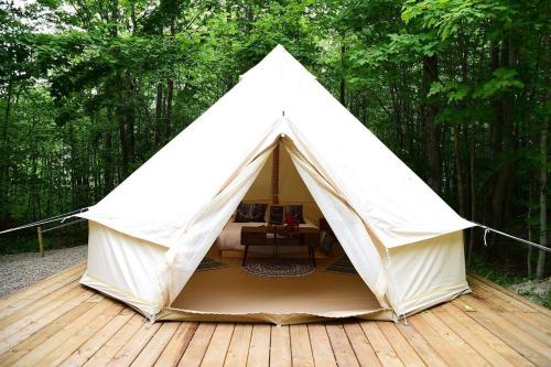 a white tent sitting on a wooden deck at Grotto Getaway in Miller Lake