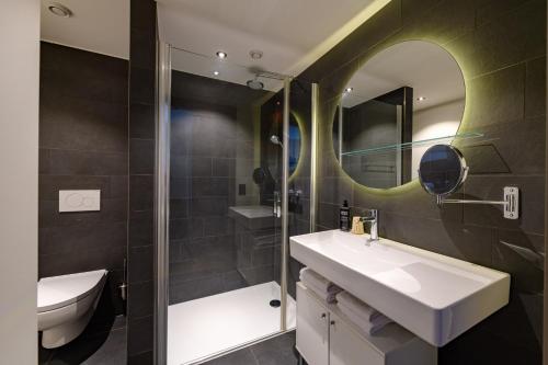 a bathroom with a sink and a mirror at Aparthotel Adagio Zurich City Center in Zurich