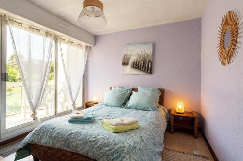 um quarto com uma cama com paredes e janelas roxas em Jonc de Mer em Saint-Cast-le-Guildo