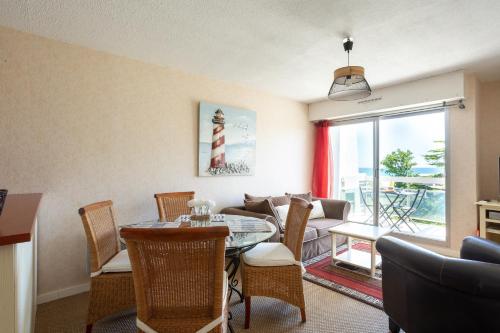 a living room with a table and chairs and a couch at Jonc de Mer in Saint-Cast-le-Guildo