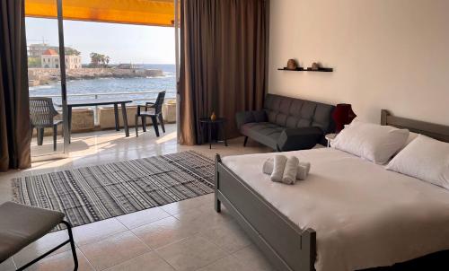 een slaapkamer met een bed en uitzicht op de oceaan bij St Paul Resort in Safra