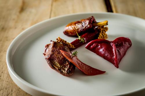 a plate of food with meat on a table at Hôtel Restaurant Gastronomique La Huchette in Mâcon