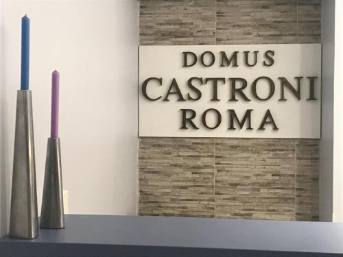 a sign on a wall with two vases on a shelf at Domus Castroni Pompeo Magno in Rome