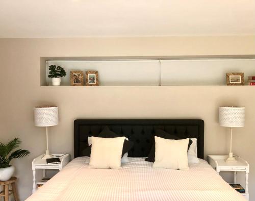 una camera da letto con un grande letto con due lampade su entrambi i lati di Gardenhouse 'The Block' - Ostend - private garden - IR cabine - AC a Ostenda