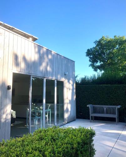 a building with a patio with a table and a bench at Gardenhouse 'The Block' - Ostend - private garden - IR cabine - AC in Ostend