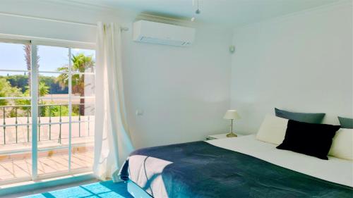 a bedroom with a bed and a balcony at Vila Castro-Cleverdetails, Quiet area, private pool in Vilamoura