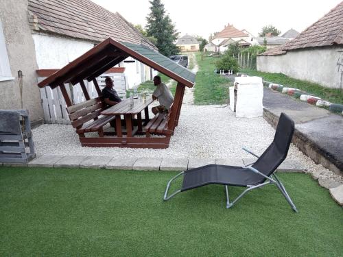 a couple of people sitting at a table in a gazebo at TITI House in Bakonykoppány