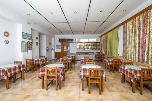 a restaurant with tables and chairs in a room at Hotel Eleni Anagros in Archangelos