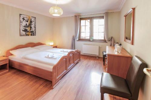 1 dormitorio con cama, escritorio y silla en VacationClub - Osiedle Podgórze 1B Apartament 6 en Szklarska Poręba