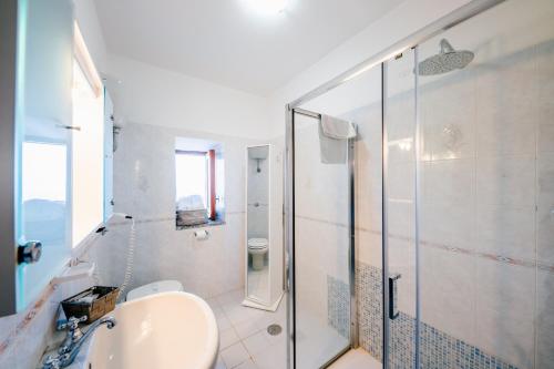 a white bathroom with a sink and a shower at Appartamento Elisa in Villa Laura in Scala