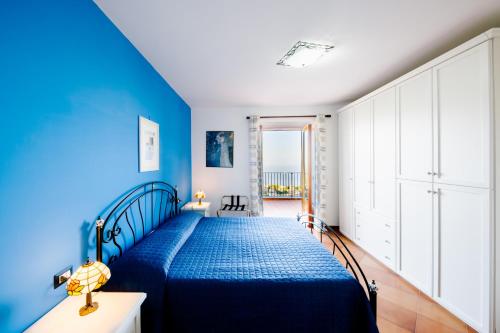 a blue bedroom with a bed with a blue bedspread at Appartamento Elisa in Villa Laura in Scala